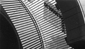 Sunlight and shadow falling through curved window blinds